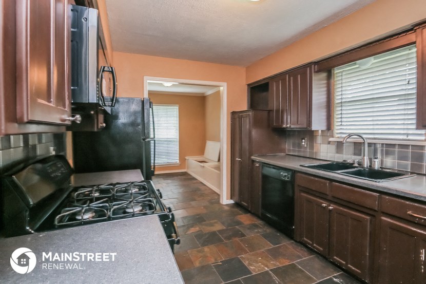 a kitchen with black appliances and brown cabinets