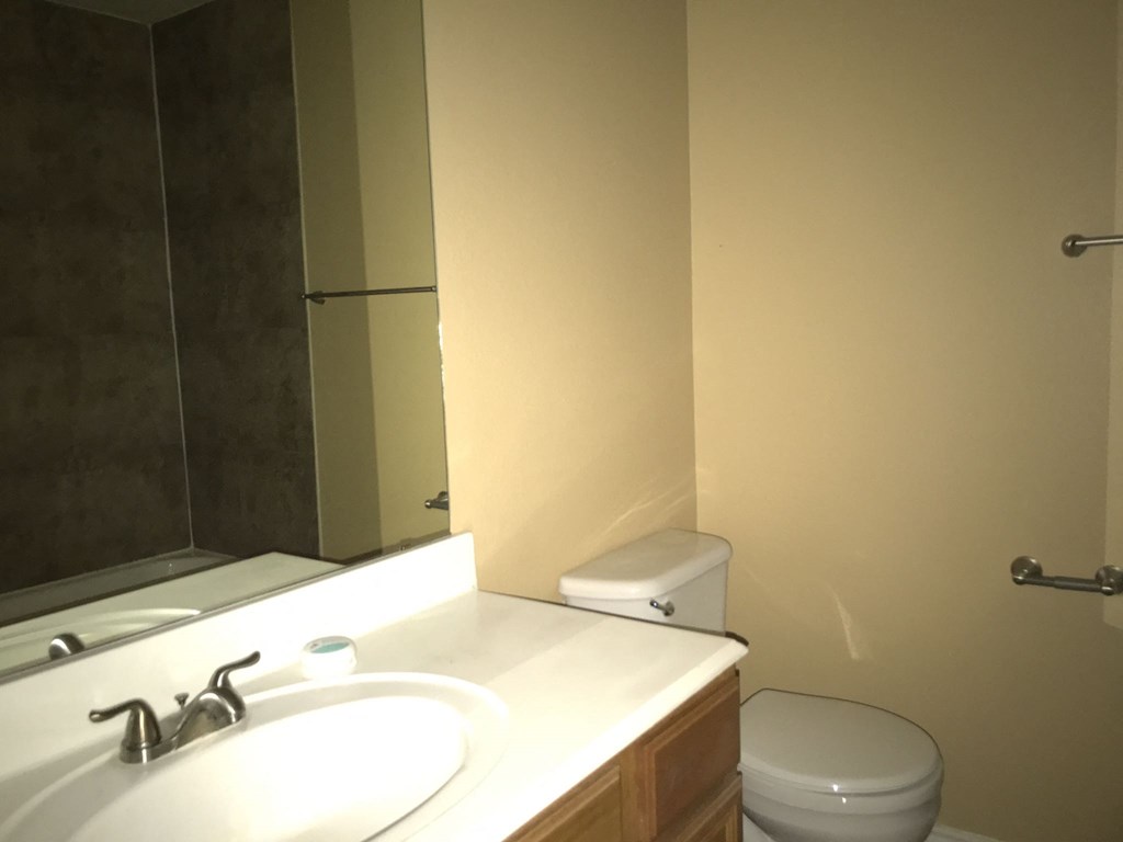 a bathroom with a sink toilet and a mirror