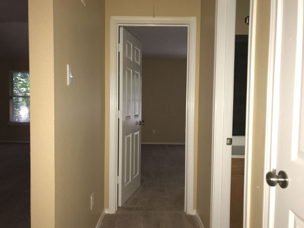 a room with a white door and a hallway with a door open