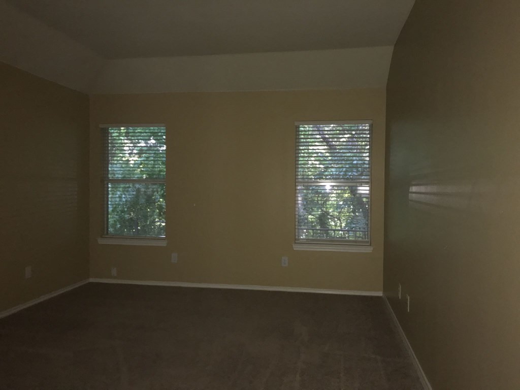 an empty room with two windows in it