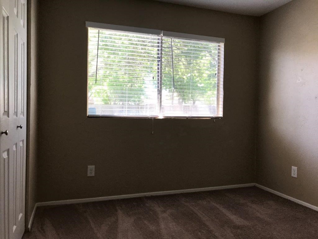 an empty room with a large window and wood floors