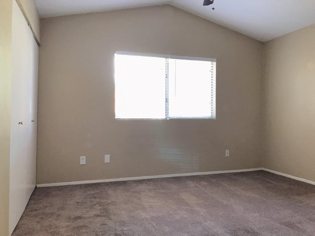an empty room with a window and carpet
