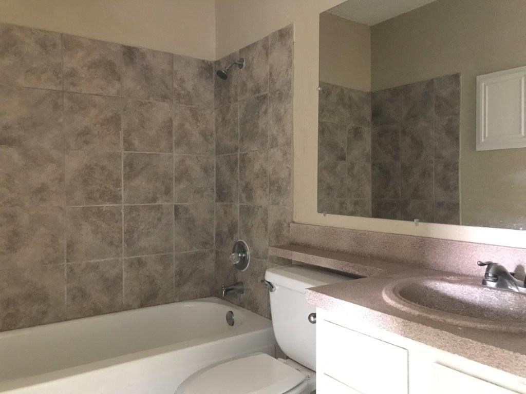 a bathroom with a toilet and a tub and a sink