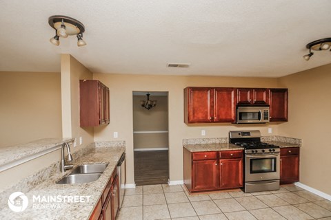 a kitchen with granite counter tops and wooden cabinets