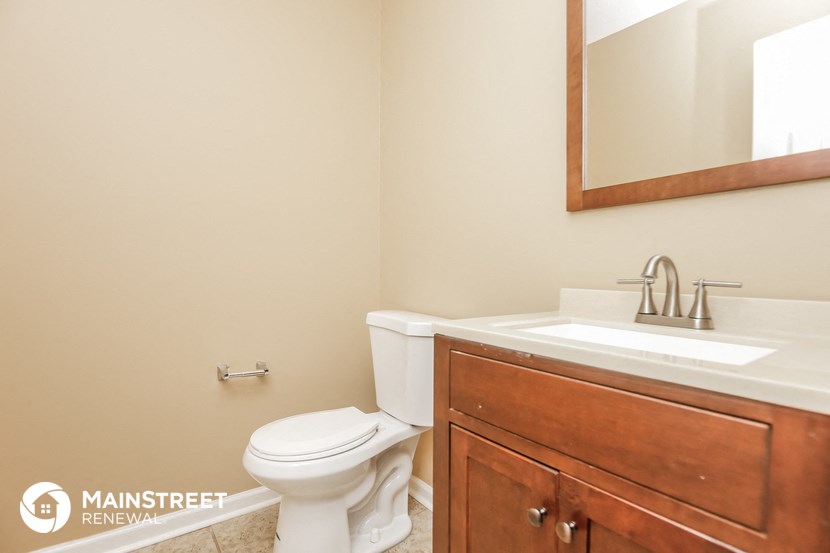 a bathroom with a toilet and a sink and a mirror