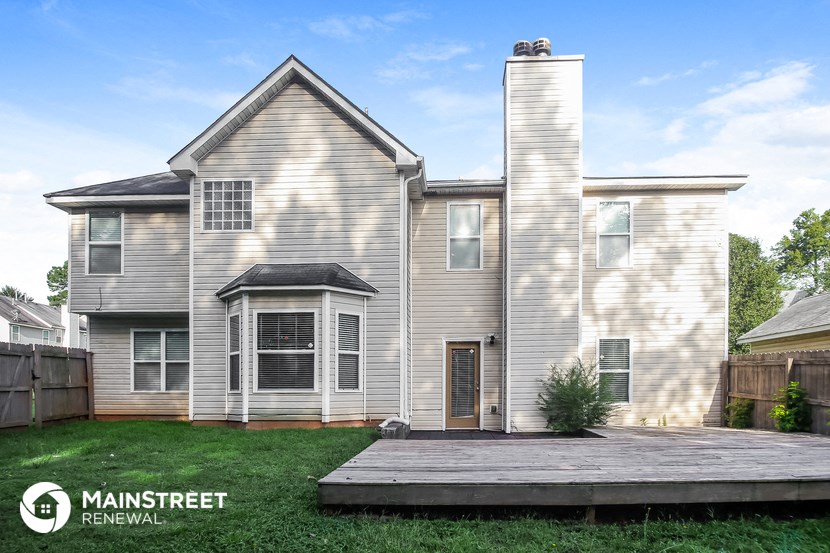 a white house with a wooden deck in front of it