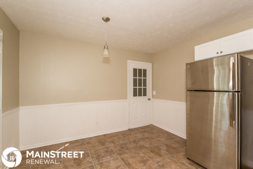 a kitchen with a stainless steel refrigerator and a door