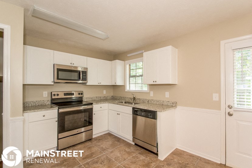 a kitchen with white cabinets and stainless steel appliances