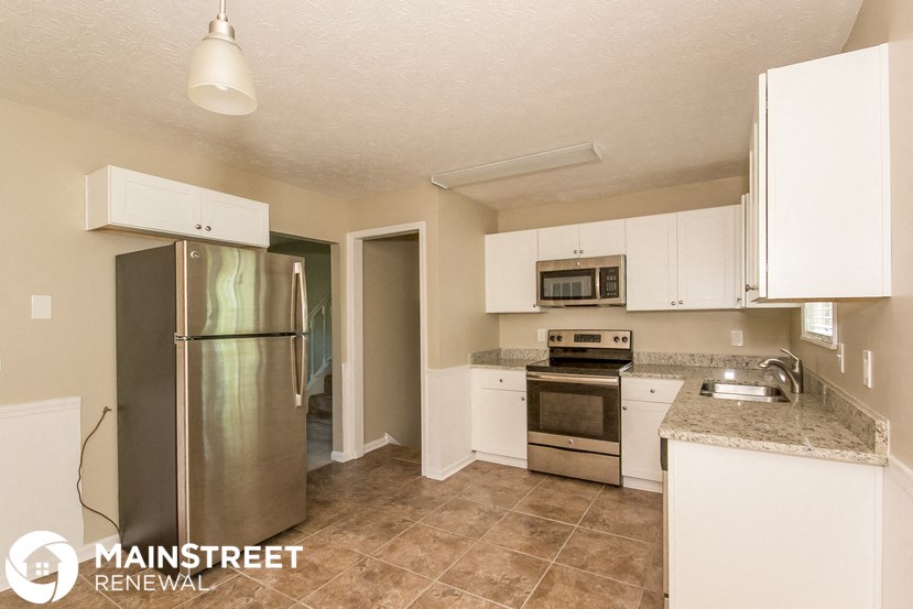 a kitchen with stainless steel appliances and white cabinets