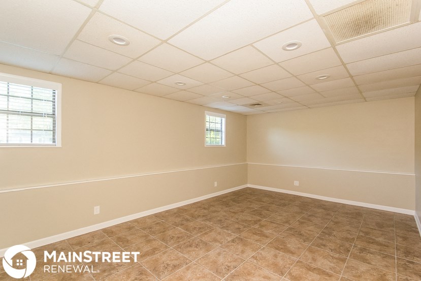 the interior of an empty room with tile flooring and a window