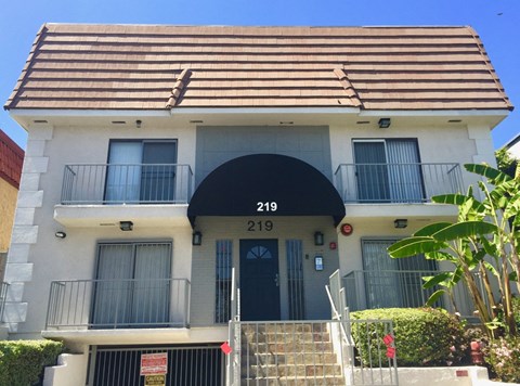 A two-story building with a black awning and the number 219 on it.