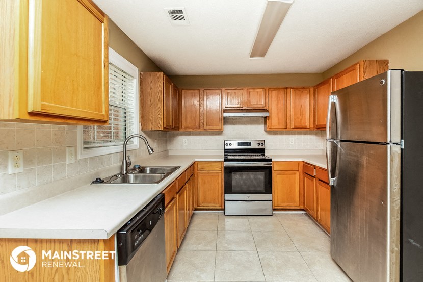 a kitchen with wooden cabinets and stainless steel appliances
