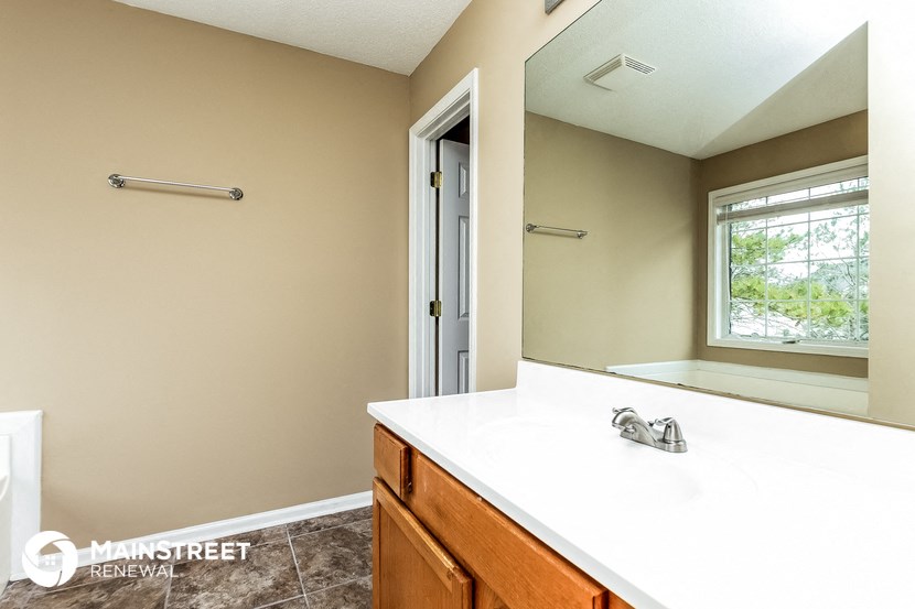 the master bathroom has a large mirror and a large sink