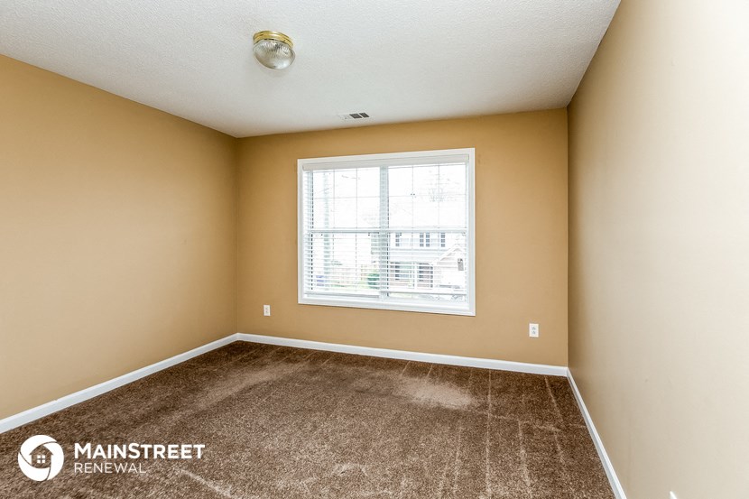 an empty room with carpet and a window