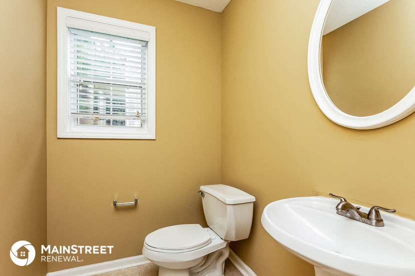 a bathroom with a toilet and a sink and a window