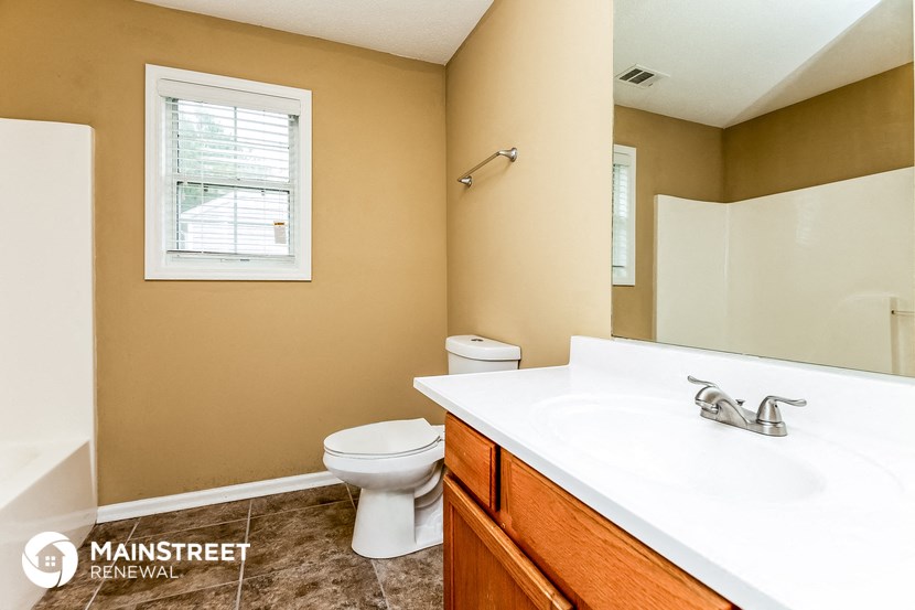 a bathroom with a sink toilet and a mirror