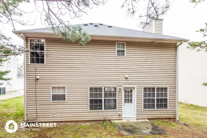 the front of a house with a white garage and a white door
