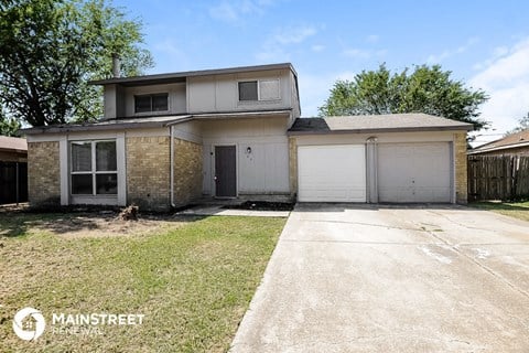 the front of a house with a driveway and a garage door