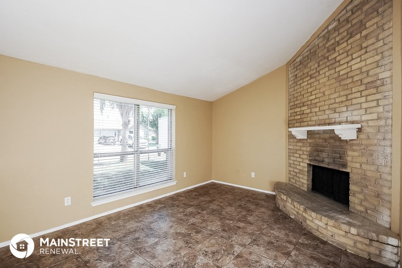 the living room has a brick fireplace and a large window