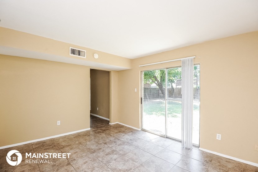 the spacious living room with sliding glass doors to the backyard