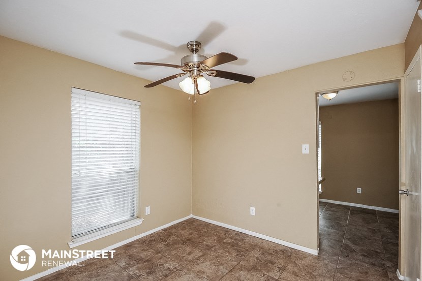 the master bedroom has a ceiling fan and tile flooring