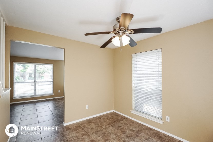 a living room with a ceiling fan and a window