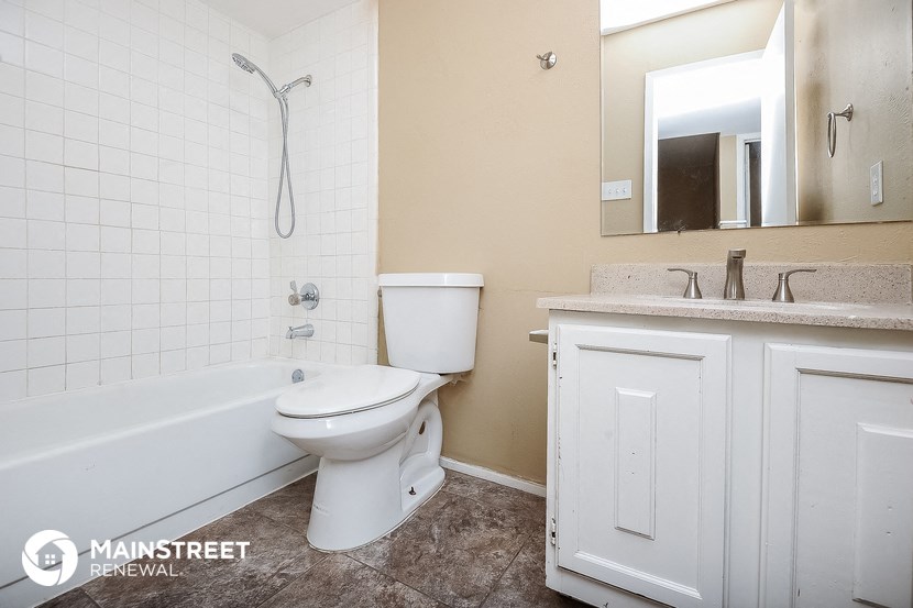 a bathroom with a toilet and a tub and a sink