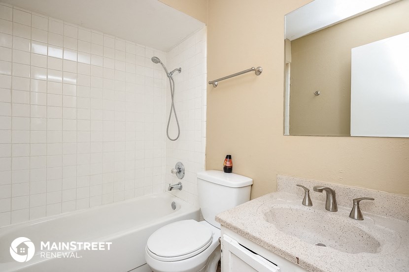 a bathroom with a toilet sink and tub and a mirror