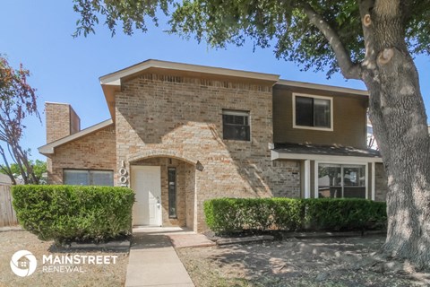 a brick house with a tree in front of it