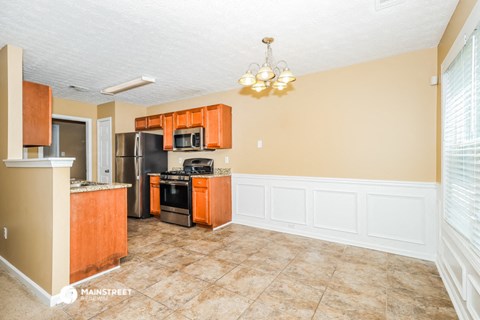 a kitchen with wood cabinets and a black stove and refrigerator