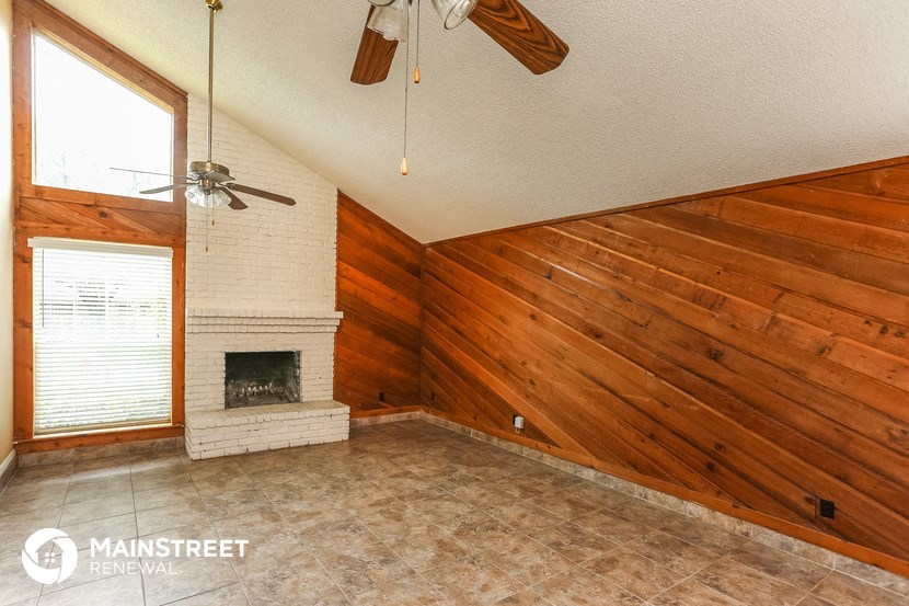 a living room with a fireplace and a wooden wall