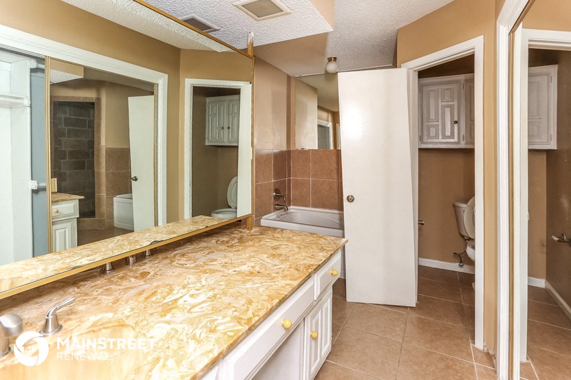 a bathroom with a large mirror and a counter top