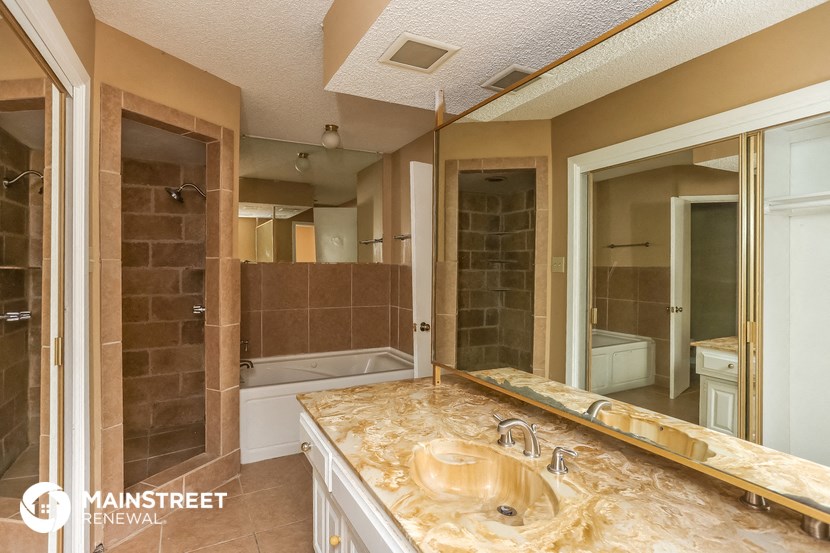 a bathroom with a sink and a tub and a mirror