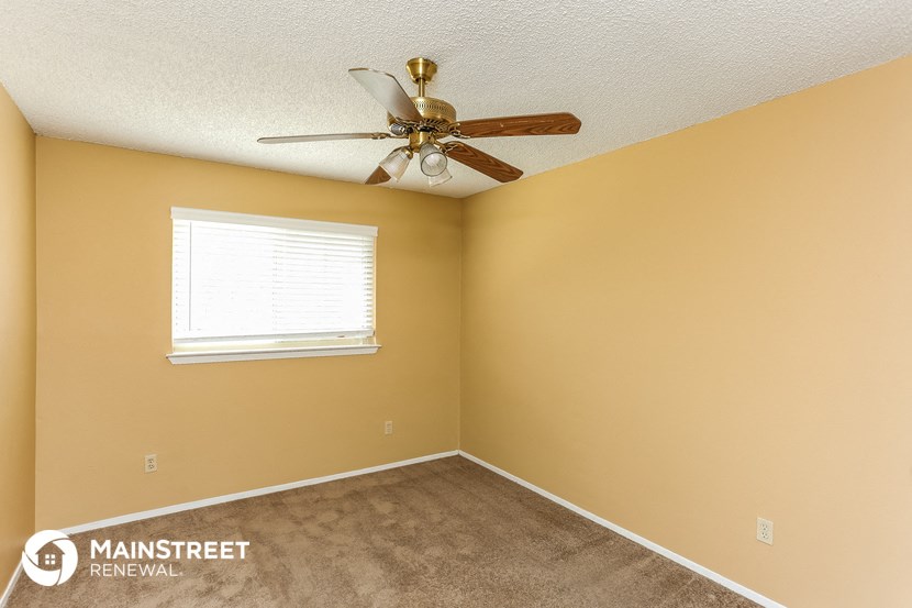 the living room of a home with a ceiling fan and a window
