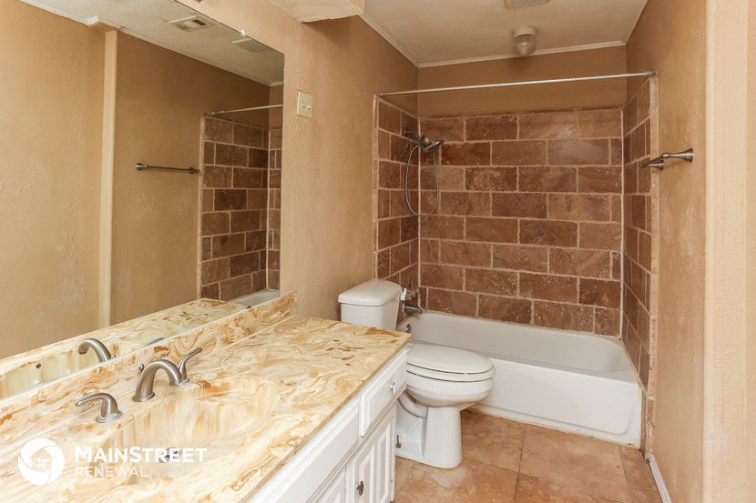 a bathroom with a white toilet and a tub and a sink
