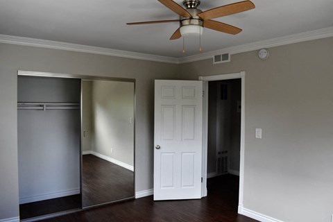 a living room with a ceiling fan and a closet