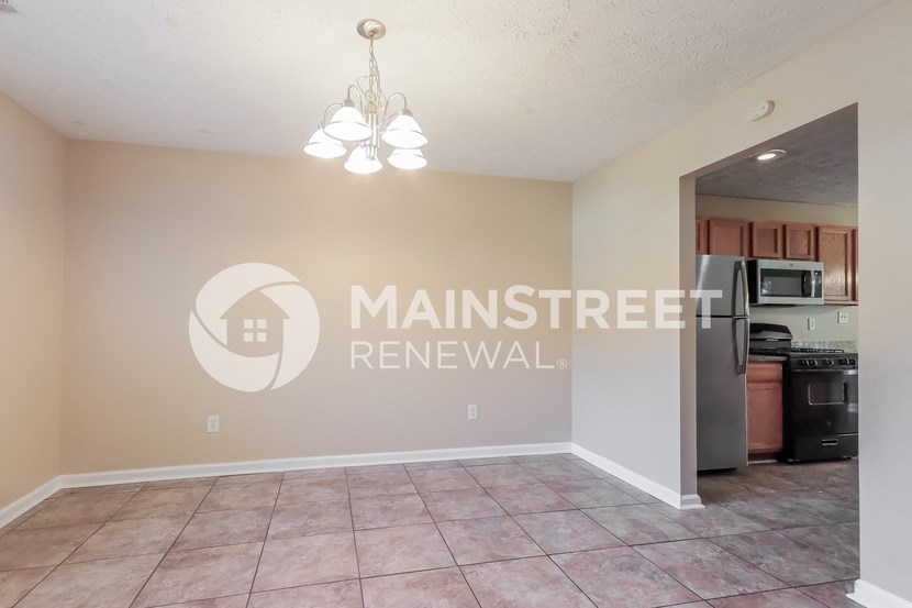 a kitchen and living room with tile flooring and a chandelier