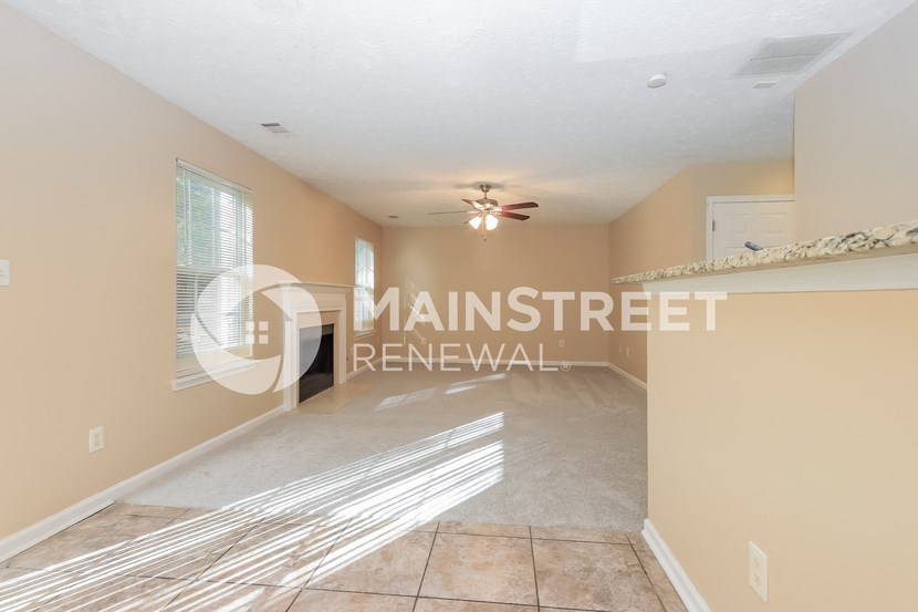 a renovated living room and dining room with tile flooring and a ceiling fan