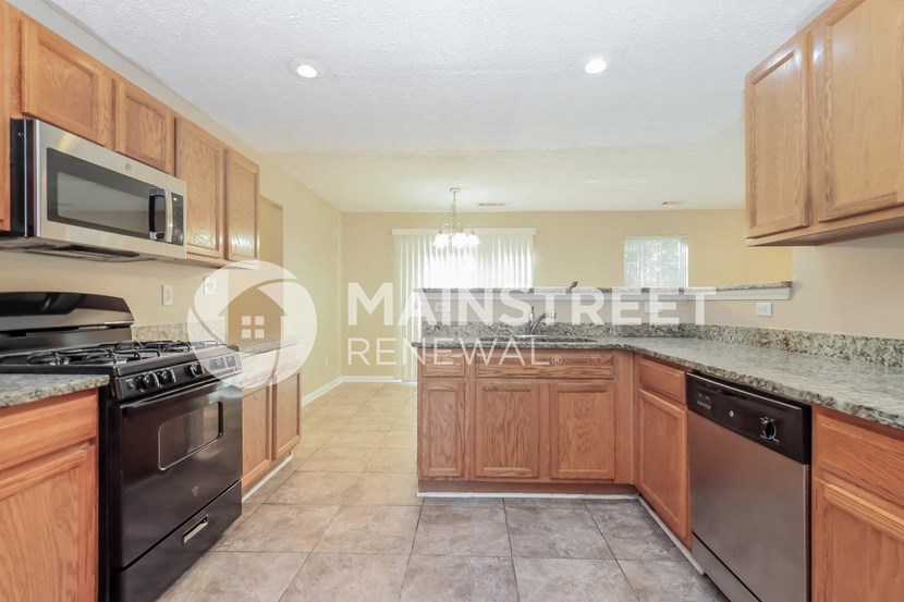 a kitchen with granite countertops and wooden cabinets