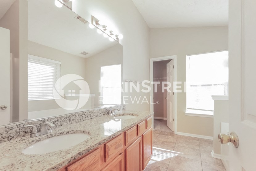 a large bathroom with two sinks and a large mirror