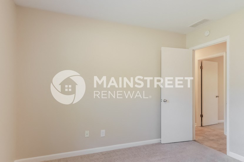 a bedroom with a closet and a door to a hallway