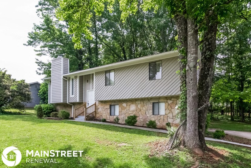 a white house with a yard and trees