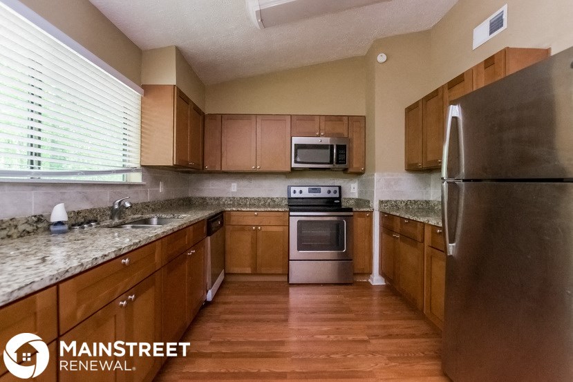 a kitchen with wooden cabinets and stainless steel appliances