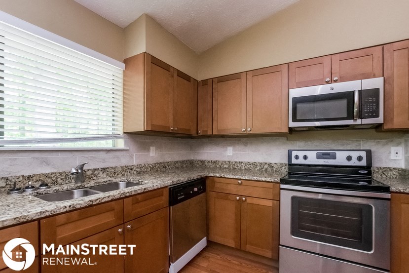 a kitchen with wooden cabinets and stainless steel appliances