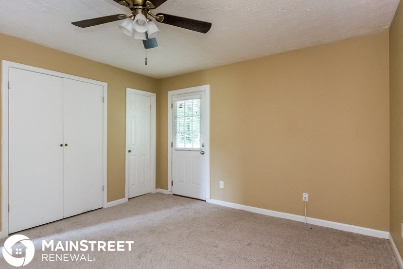 a living room with a ceiling fan and two doors