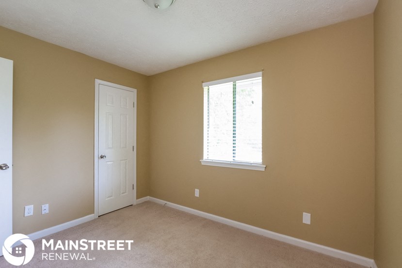 a bedroom with a white door and a window