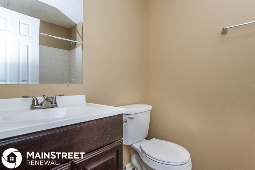 a bathroom with a toilet and a sink and a mirror