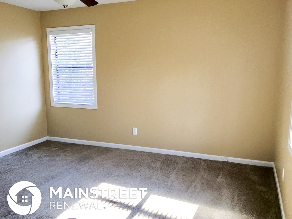a room with a carpeted floor and a window