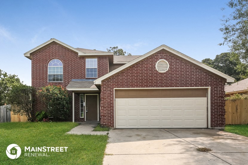 the front of a brick house with a white garage door