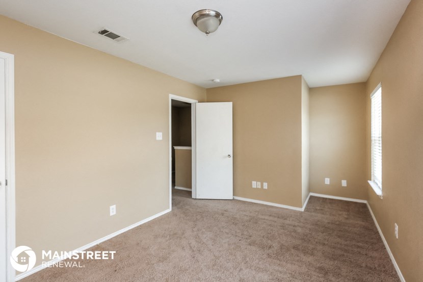 an empty living room with carpet and a door to a closet
